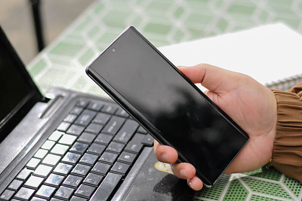 istock woman's hand holding a modern smartphone on a desk 2228870422