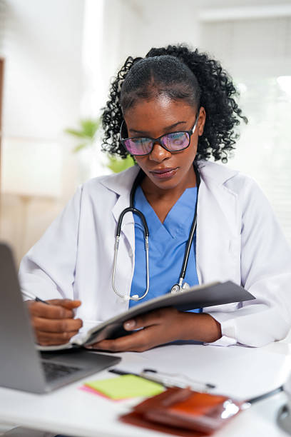 istock Young Black Woman Doctor Concentrating on Important Documents 2228872123