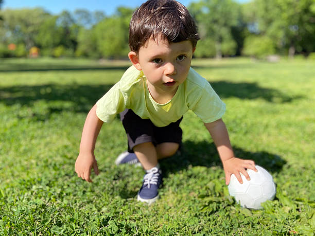istock Boy playing with a ball at park 2228874358