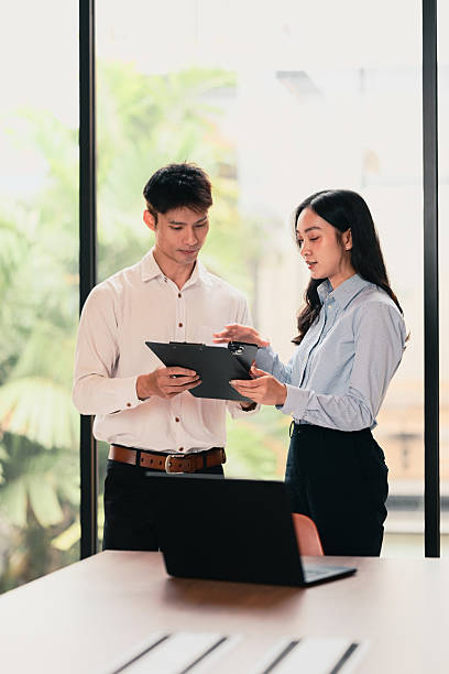 istock Business colleagues standing and discussing documents during a team meeting 2228879107