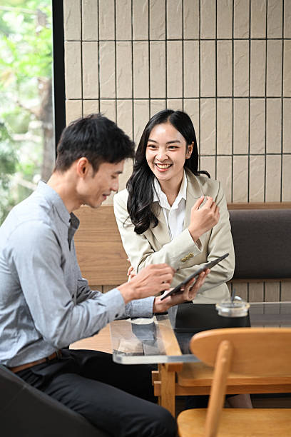 istock Two young businesspeople sharing ideas and collaborating on a project in modern office 2228879128