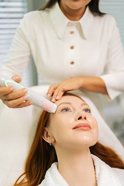 istock Beautician performing mesotherapy treatment using specialized tool on relaxed client face during professional skincare procedure in beauty salon. 2228879720