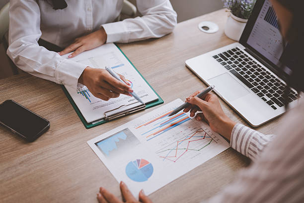 istock Businesswomen analyzing financial charts and data at office desk 2228880971