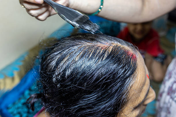 istock elderly woman dyeing hair under home lighting 2228881301