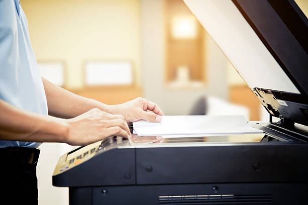 Copier printer, Close up hand office man place A4 paper on panel to using the photocopier or photocopy machine for scanning document printing a sheet paper and xerox photocopy.