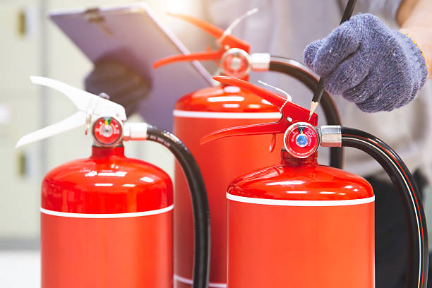 istock Fire extinguisher has hand engineer inspection checking pressure gauges to prepare fire equipment for protection and prevent emergency and safety rescue and alarm system training concept. 2228884172