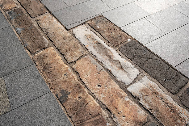 istock Old sandstone building foundation amongst modern tiles 2228884559
