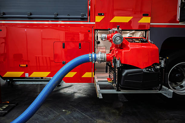 Fire Engine Pumping Equipment Connected with Blue Hose inside Red Truck for Firefighting Actions.