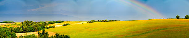 Landscape with rolling hills on the plateau of Valensole in the Provence during a summer thunderstorm with a rainbow on the horizon. Valensole is a commune in the Alpes-de-Haute-Provence department in the southeastern Provence-Alpes-Côte d'Azur region of France.
