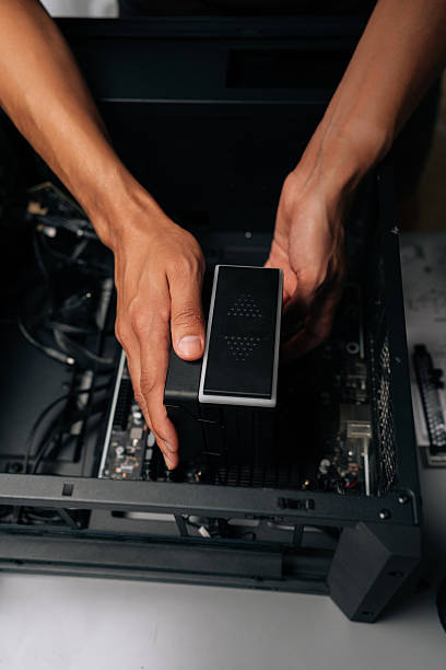 istock Vertical cropped shot of technician installing CPU water cooler into desktop computer case, showcasing process of computer maintenance and upgrade. 2228888381