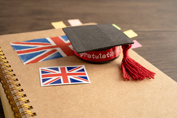 istock UK flag with graduate hat on english language book. 2228889381