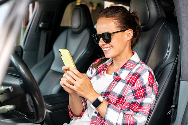istock Woman driver checking smartphone while sitting inside parked car. 2228889482