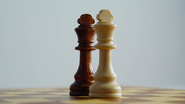 istock Two royal chess pieces placed on board closeup. Dark light game kings standing 2228889514