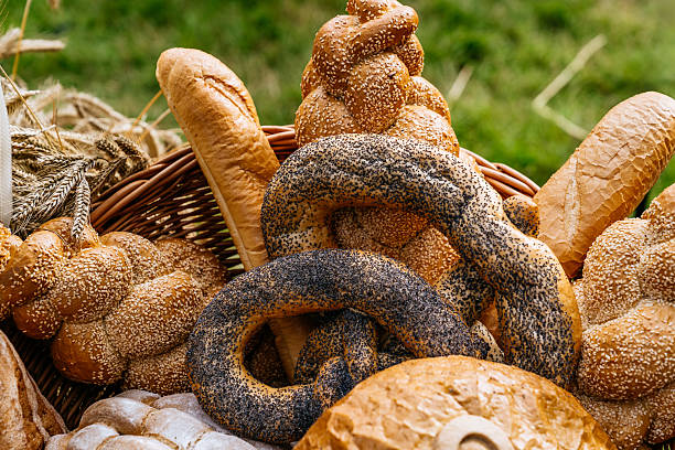 Basket of Mixed Bread Loaves and Rolls with Seeds and Crusty Textures Set Outdoors on Straw Surface in Gdańsk Market