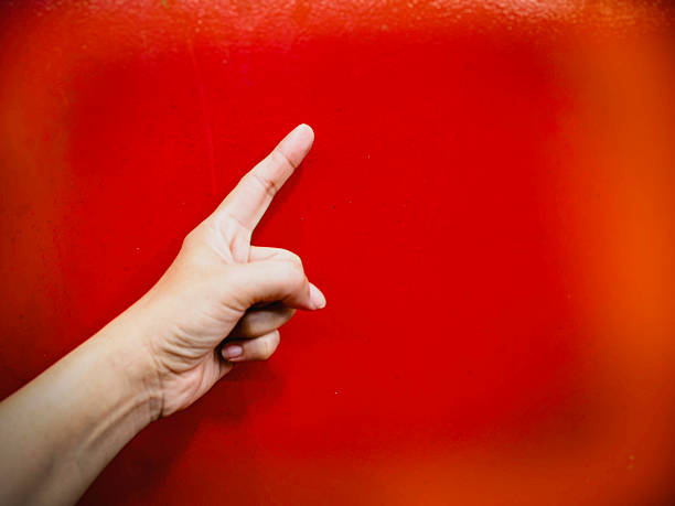 Finger point up in the air.Human hand sign in front of blurred background.