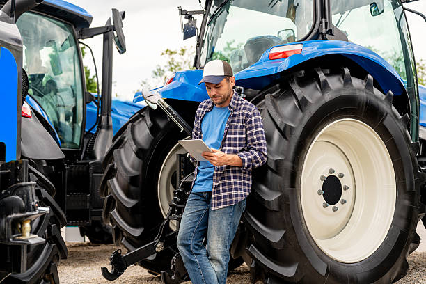 istock Male farmer using digital tablet near agricultural tractors 2228891901
