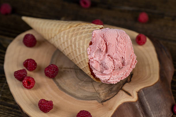 istock pink raspberry-flavored ice cream lies on a walnut board, ripe red raspberries and raspberry cold natural ice cream on the table 2228892606