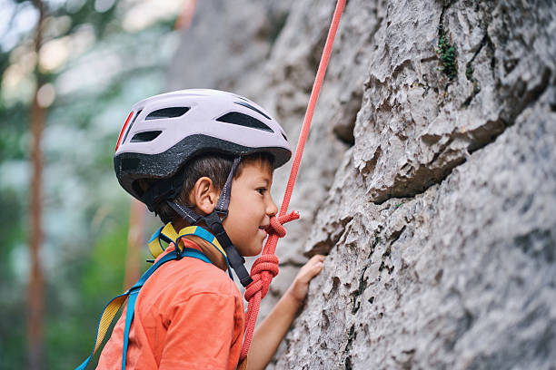 Little girl climbing an artificial climbing wall in a playground, developing strength and coordination. High quality photo