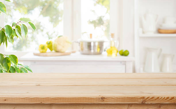 istock Empty wooden table with bright blurred kitchen interior and healthy food cooking ingredients as background 2228894949
