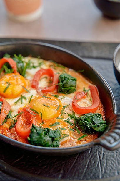 istock Deliciously Baked Eggs with Spinach, Red Peppers, and Fresh Herbs Served in a Cast Iron Dish for a Hearty Breakfast Experience 2228902210