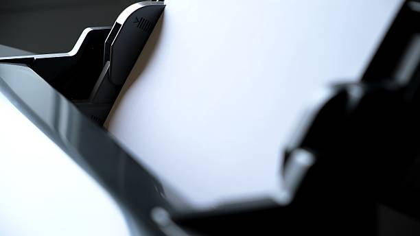 istock Printer paper tray close-up. Loading a sheet. Printing process. A paper comes into the color inkjet printer. Office equipment. Side view. Working B-roll. Copy space. High quality 2228903038