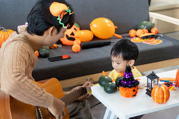 istock Halloween Fun. Father sharing musical moments with son surrounded by decorations. 2228904609
