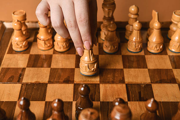 istock Woman’s Hand In Motion Positioning Chess Piece For Possible Attack 2228910721