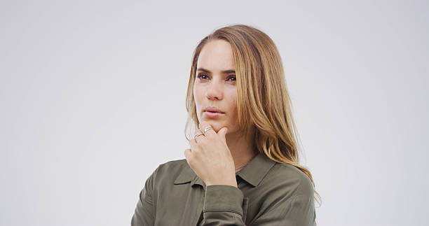 Ideas, planning and thinking with woman on studio space for brainstorming, contemplation or wonder. Choice, decision and why with face of person isolated on white background for thought or vision