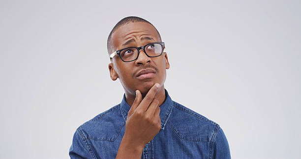 istock Thinking, question and why with black man on studio space for brainstorming, contemplation or solution. Glasses, ideas and planning with person isolated on white background for choice or decision 2228911440