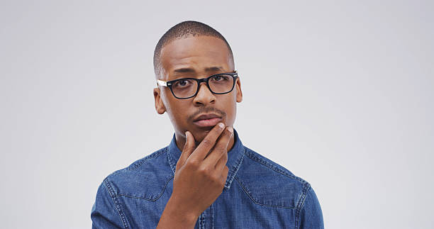istock Portrait, thinking and black man with question in studio for why, suspicious and solution to doubt. Mockup space, person and wondering on white background for fake news gossip, uncertain and puzzled 2228911441