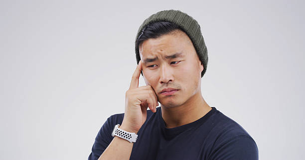 istock Thinking, ideas and man in studio with uncertain for decision, brainstorming or question. Choice, mockup space and Asian male person with problem solving, planning or doubt by white background. 2228911467