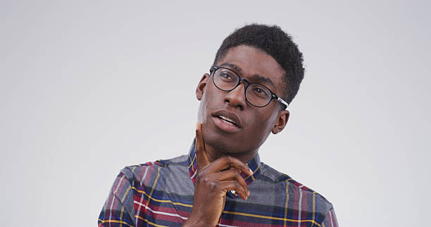 istock Black man, thinking and college student in studio, confused or doubt with mockup space on white background. African person, nerd and insight for learning, solution or choice for university education 2228911526