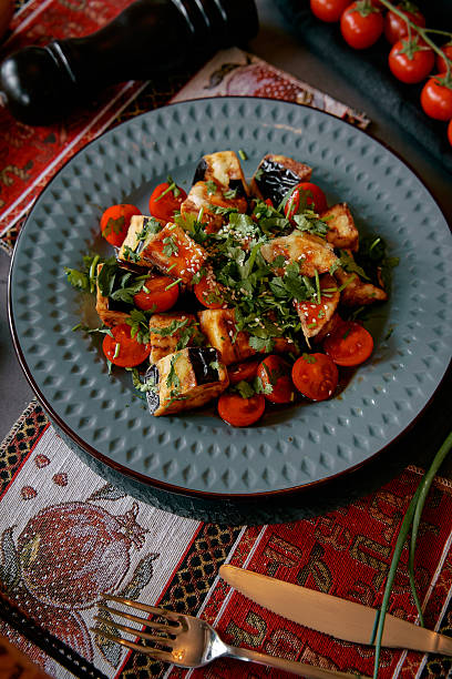A Colorful and Flavorful Arrangement of Fresh Salad Featuring Grilled Vegetables, Cherry Tomatoes, and Vibrant Garnishes on a Decorative Plate