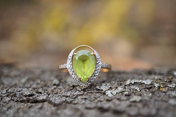 istock A precious ring with chrysolite on a wooden background. 2228921029