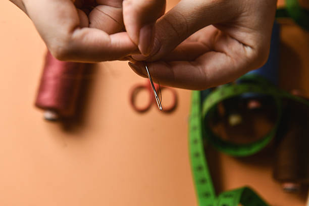 istock Close-Up View Of Female Hand Threading Needle With Bright Colored Thread 2228921150