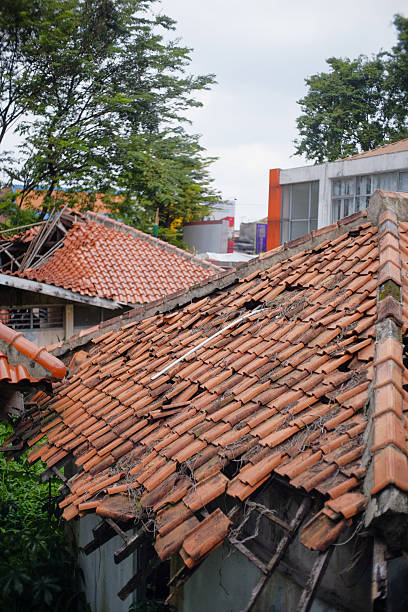 istock Dilapidated clay tiled rooftops reveal weather damage and structural issues offering a poignant view of aged infrastructure and potential decay urban landscape maintenance challenges 2228921319