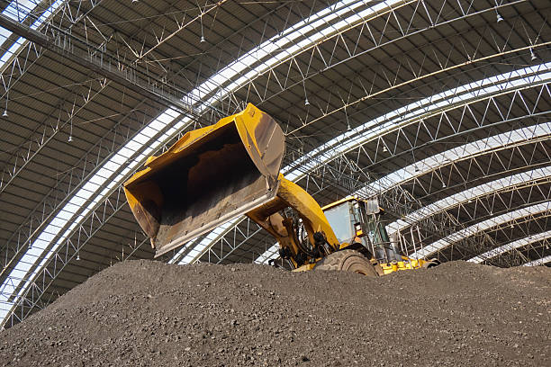istock Heavy machinery at work: A yellow bulldozer scoops pile under arched structure 2228921485