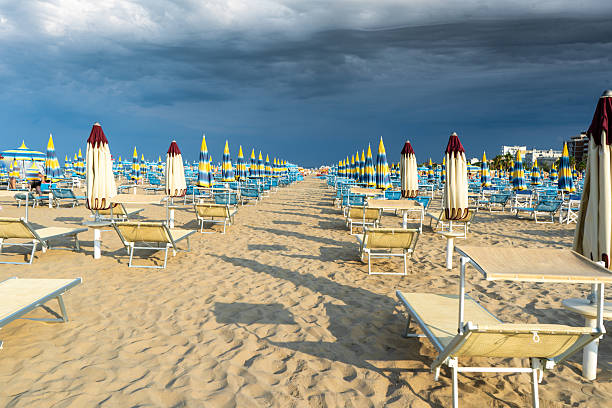 istock Beach with Umbrellas and Deck Chairs on Sand. Sky before rain storm. 2228922118