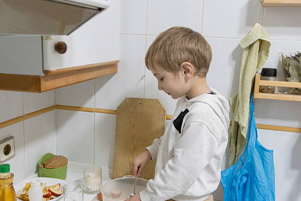 istock Young child preparing food in kitchen: learning culinary skills 2228922444