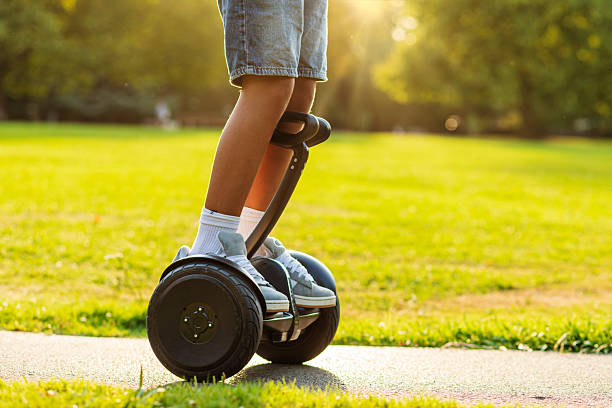 istock Eco-friendly urban mobility: boy riding smart scooter in park 2228923455