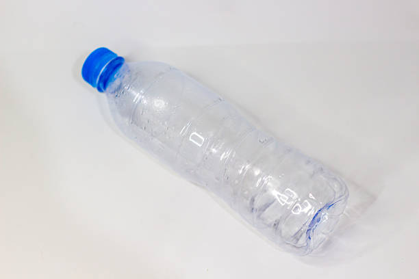 Close-up of an empty clear plastic water bottle with a blue cap, promoting responsible hydration and environmental awareness on a clean white background fostering mindfulness.