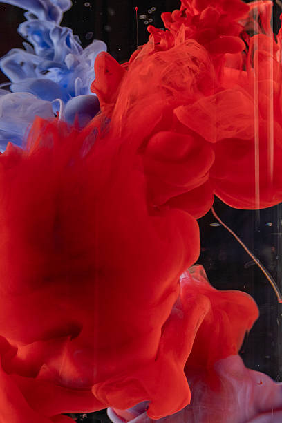 istock Vibrant red and blue ink swirling and diffusing in water, creating a dynamic and ethereal visual. 2228929601
