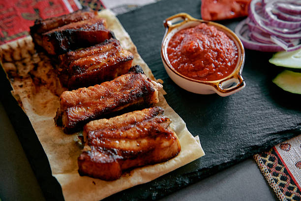 Delicious Grilled Meat Dish Served with Spicy Salsa and Fresh Vegetables on a Rustic Platter, Perfect for Savory Food Lovers Who Enjoy Authentic Flavors