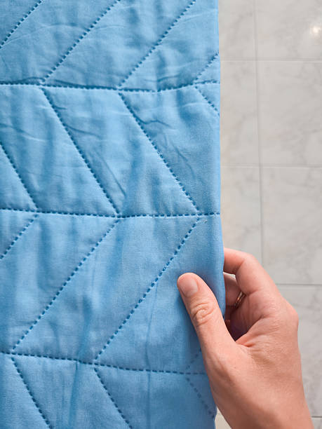 istock Hand touching soft blue quilted fabric in bathroom 2228932641