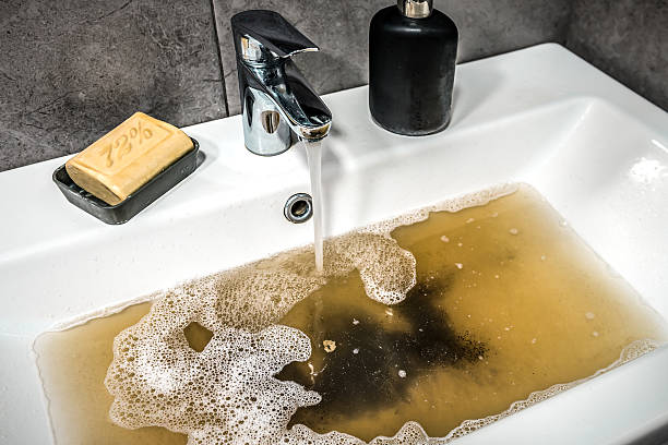 istock Clogged sink in bathroom, sink with dirty water, brown soap. Plumbing problems 2228932869