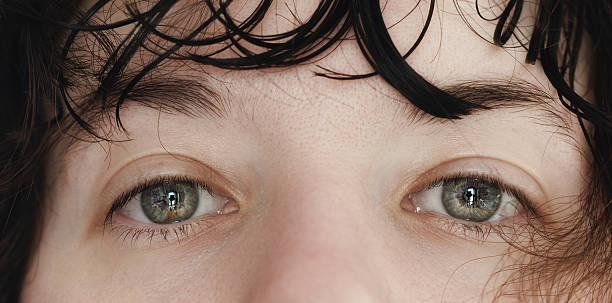 istock Grey-blue eyes looking at camera, closeup 2228933102