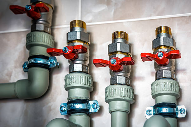 istock Complex plumbing system featuring brass and plastic pipes, equipped with red valves for water flow control 2228933476