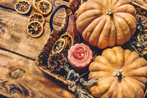 istock Cozy warm autumn composition with burning candle and pumpkins on knitted woolen plaid. Autumn home decor. Fall mood. Thanksgiving. Halloween. 2228934607
