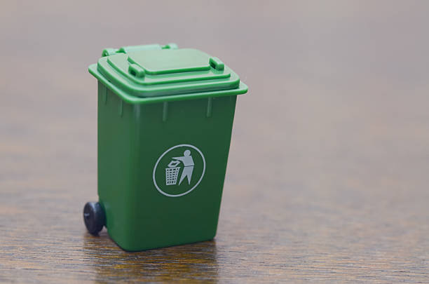 istock Miniature Green Bin with Universal Trash Disposal Symbol on White Background 2228936074