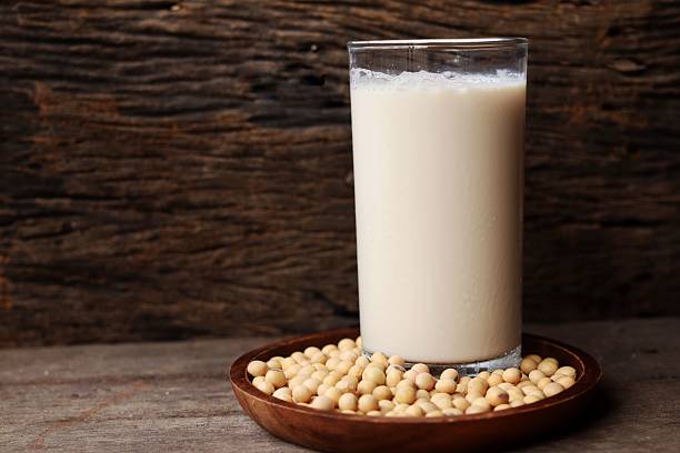 istock Soy milk with soybeans on wood background 2228937402